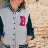 woman wearing light gray cotton varsity jacket