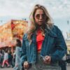 Woman wearing a denim jacket at an amusement park